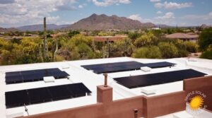 Flat roof on a stucco home with solar panels installed. Behind the home is an amazing view on mountains in teh distance and desert foliage in Cave Creek, Arizona